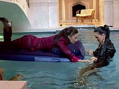 Sexy lezzies are bathing in water in their clothes. Tracing their hands over each other's bodies they get horny. So, they start spicy lesbian sex right in the pool.