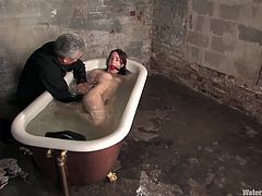 Watch this hot clip where a sexy brunette's tied up before putting a gag ball in her mouth and dipping her in a tub filled with water.