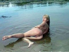 Blonde bitch gets naked and gets in this sandy river where she fondles her tight body for the camera, check it out right here!