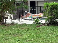 Stunning mommy sun bathes outdoor lying on a deck chair by the poolside. The guy offers his service to apply sun protect lotion on her back. So he smears the lubricant on her back and bottom. He rubs and squeezes her butt cheeks.