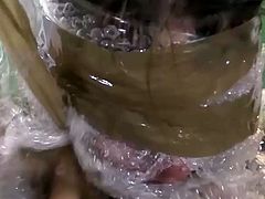 Perverted dudes wrap the girl with plastic tape. They leave her mouth and nose unwrapped. They throat fuck her hard. Later on in a clip they bend her over the table and make a big hole from behind. They stuff her anus with fat stick so her ass hole is stretched wide as fuck.