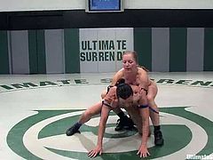 A blonde and a brunette fight in a ring showing good wrestling skills. Wenona loses, so she gets her pussy and ass toyed with a strap-on.