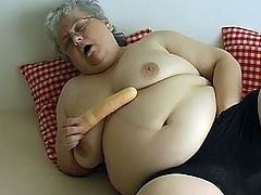 Filthy tome worn SSBBW granny shows off her ginormous saggy tits. Old fat whore takes off her panties and rams her fat shaved cunt with big plastic dildo.