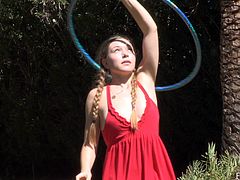 Watch the beautiful Aurielee taking off her clothes as she plays with her hula hoop butt naked in the patio.