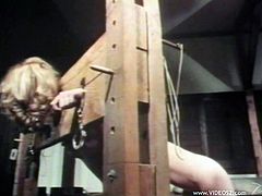 Kinky tied up blonde is lying on the floor. Brunette mistress pets the bitch and then pleases her with cunnilingus in retro BDSM sex clip.