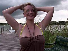 A big breasted girl walks around a park. She pulls down a dress to show her juicy boobs. She massages them with a smile on her face.