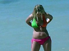 Gorgeous porn star in a sexy bikini removes it showing her lovely natural tits then she turns showing her hot ass at the beach