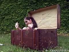 This beautiful brunette comes out of a box positioned outdoors. She is so tiny and skinny that she can fit in that box without a problem. She is also very flexible.