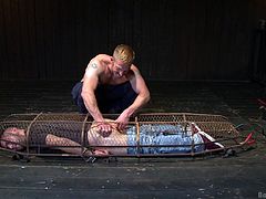 With the cage on the ground the gay slave is locked in it. The slave has to face the floor with his ass up. The master fingers the slave's butthole before shoving his cock inside the slave's tight asshole.
