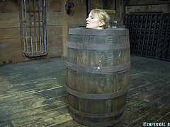 Not a single part of this slave's body is showing. Only her head is visible as it stick out of a hole in the barrel that her master has locked her in. The cute slave has hooks put in her nose and pulled.