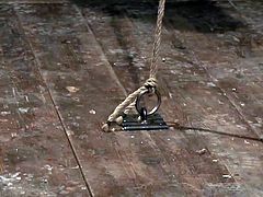 This gay slave hunk is tied up in rope and the master has hanged him from the ceiling. The slave has rope tightly wrapped around his cock and ball and the master give the rope a tug. This makes the gay slave sway back and forth.