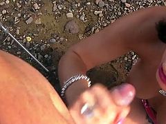 Skanky brunette girl gives head by the river under the open sky