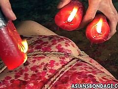Asian hottie is all tied up and she gets fucked at the same time by her master. She lets her moans out but then the wax comes. Hot pouring wax all over her sexy curvy body.