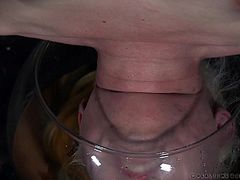 Dresden is into getting dominated, and her executor has something a little extreme in mind for her. She's hung upside-down, with her head in a fishbowl. He has a bucket of urine to pour in it, when ready. First, he buzzes her pussy with a vibrator.
