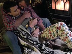 In the cabin, it's cold. A fire is in the fireplace to warm things up, and this young man and his stepdad are getting ready to bed down for the night. Before the resting begins, they get tender with one another, undressing and making love.