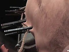 Golden-Haired slavemaster hottie in corset flogging a lad in pillory after castigation