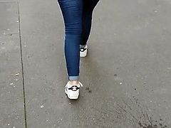 Round ass in blue jeans walking in the street