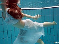 Stunning red haired porn model Marketa shows striptease under the water
