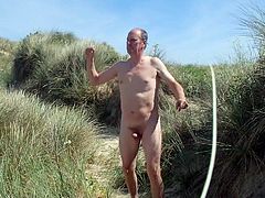 Male nudist dancing naked & free in the beach dunes.