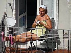Tanned granny sunbathing on the balcony